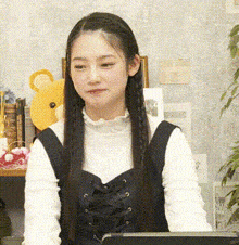 a girl with long hair is sitting in front of a shelf with stuffed animals .