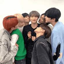 a group of young men are posing for a photo and one of them is wearing a green sweater