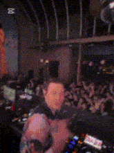 a woman in a tie dye shirt is standing in front of a dj mixer .