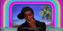 a man in a hat is covering his mouth in front of a window that says started this with are leaving the villa
