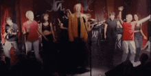 a group of people standing in front of a microphone with the letter n on the wall behind them