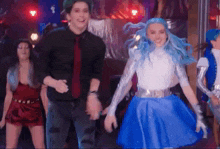 a man and a woman are dancing together in a room . the woman has blue hair .