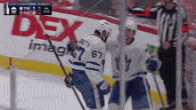 a hockey game is being played in front of a dex advertisement