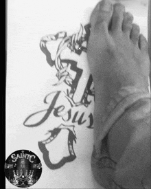 a black and white photo of a person 's foot with a jesus drawing on it
