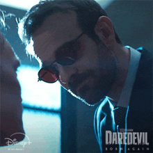 a poster for daredevil born again shows a man wearing glasses