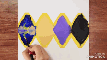 a person is painting with a brush on a piece of paper that says made in animonica