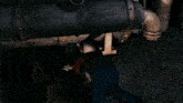 a man with a tattoo on his face is laying under a barrel .