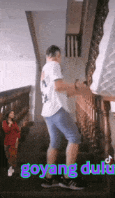 a man is dancing on a set of stairs with the word goyang displayed