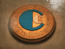a gold coin with the words character excellence tradition on it