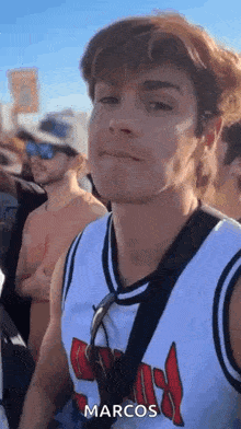 a young man wearing a chicago bulls jersey is standing in a crowd of people .