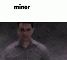 a man is standing in front of a white background with the word minor on it