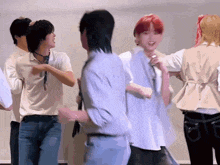 a group of people are dancing in a room and one of them has red hair