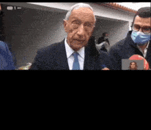 a man in a suit and tie is wearing a blue mask
