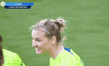 a female soccer player is smiling in front of a scoreboard that says 11 popp 2 goals in 9 matches