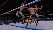 two men are wrestling in a ring with a referee