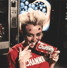 a woman wearing a red shirt that says channing is eating a channing bar