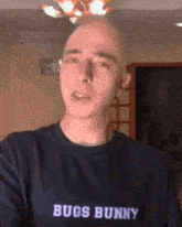 a bald man wearing a bugs bunny shirt looks at the camera