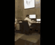 a person is sitting at a desk with a computer and a laptop .