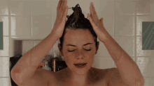 a woman is washing her hair in a bathroom with her eyes closed