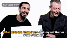 two men are laughing and holding a sign that says what does riz ahmed do ? ask myself that as well