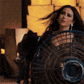 a woman with blood on her face holds a fan in her hand