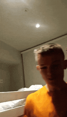 a blurry picture of a boy in an orange shirt in front of a bunk bed