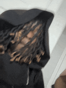 a blurry picture of a person with dreadlocks wearing a hoodie