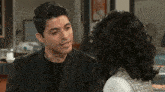 a man and a woman are looking at each other .