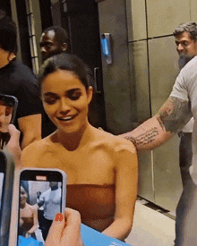 a woman with a bandage on her arm is being photographed by a man with a tattoo on his arm