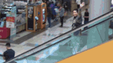an escalator in a shopping mall with a copy key kiosk in the background