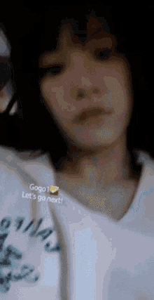 a woman wearing a white shirt with the words gogo let 's go next on it