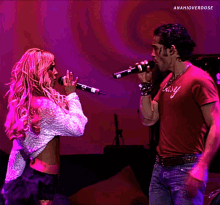 a man and a woman are singing into microphones and the man has a shirt that says easy on it