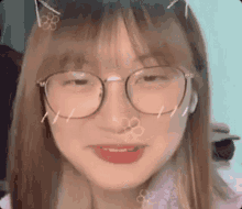 a young girl wearing glasses and cat ears is making a face .