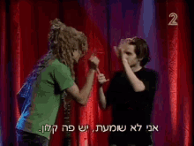 two men are standing in front of a red curtain and the number 2 is on the bottom right