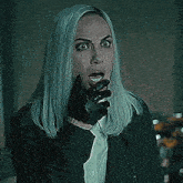 a woman with gray hair is wearing a black glove and a black jacket .
