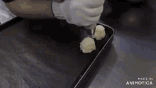 a person is holding a piping bag over a tray that says made in animonica
