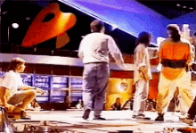 a group of people are dancing on a stage in front of a large b