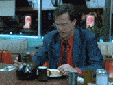 a man sitting at a diner table with a plate of food