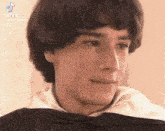 a close up of a man 's face with a white collar and a black shirt .