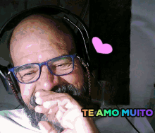 a man with glasses and a beard wearing headphones with the words te amo muito above him