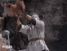 a monkey is holding a chicken in a scene from the archives of the apes