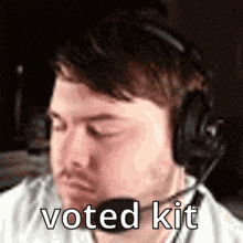 a man wearing headphones and a microphone with the words `` voted kit '' written on it .