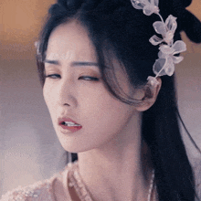 a woman with a flower in her hair is making a face