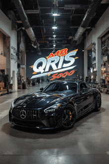 a black car is parked in front of a sign that says mb qrs 5000