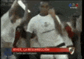 a man in a white shirt is singing into a microphone while dancing in front of a crowd .