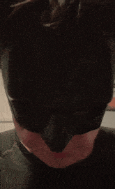 a man wearing a black batman mask makes a face