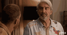 a man with a beard is talking to another man with a netflix logo in the corner