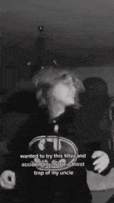 a woman is taking a selfie in a black and white photo while wearing a batman hoodie .