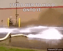 a gif of a hose spraying water with the words i told her to hold onto it .