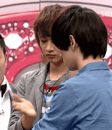 a man in a blue shirt talks to another man